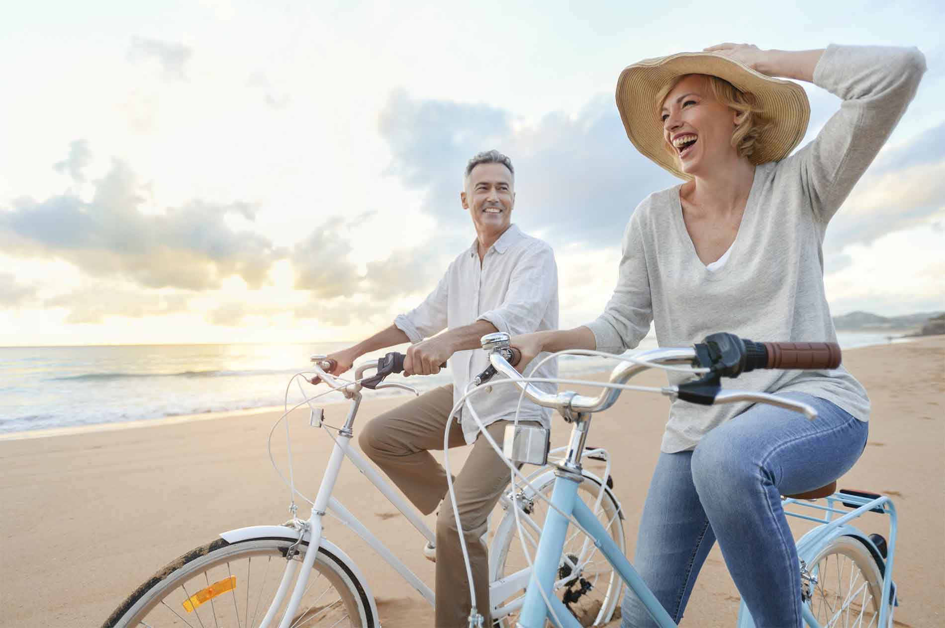 Man and woman riding bicycles on the beach