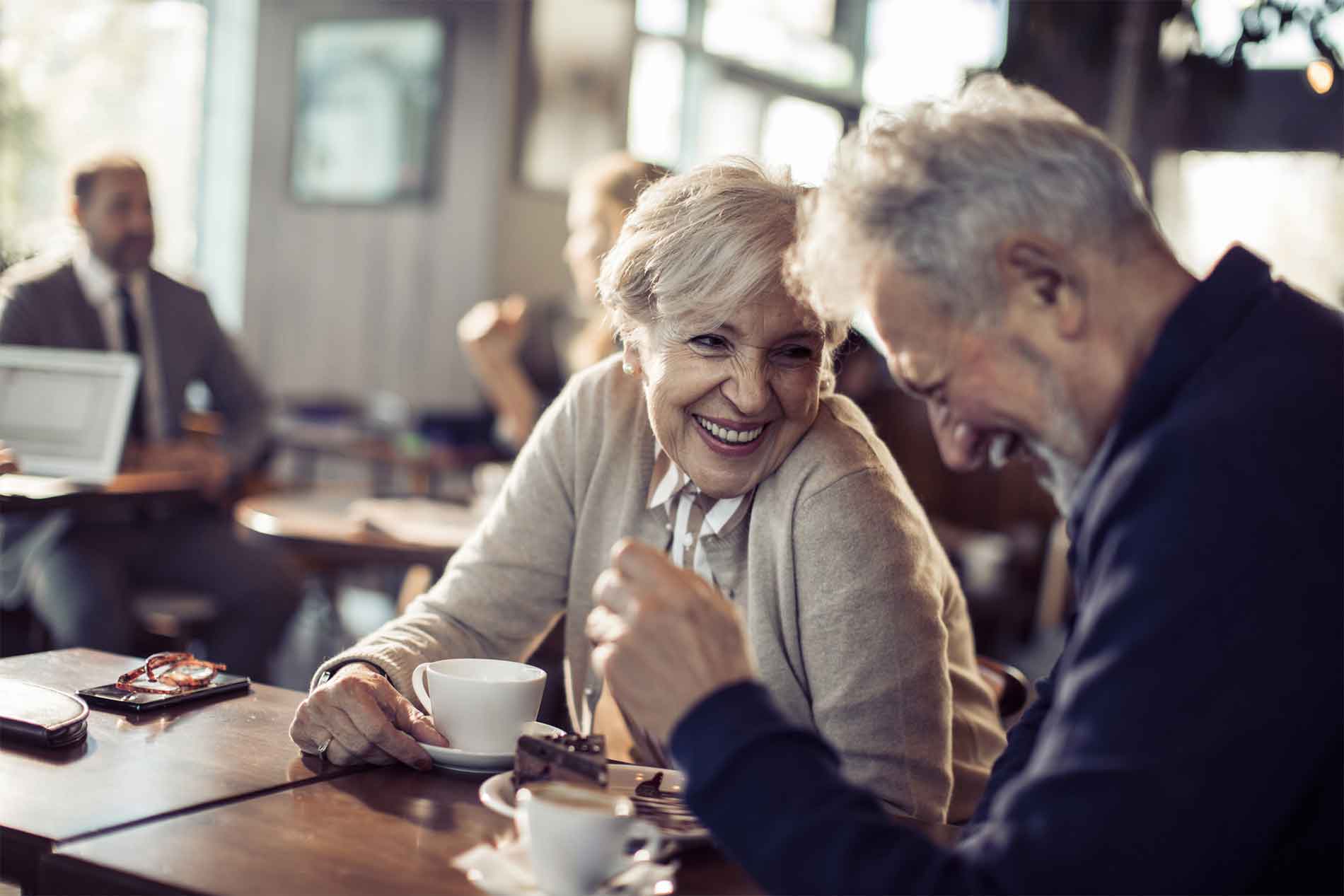 Man and woman laughing over coffee at a cafe